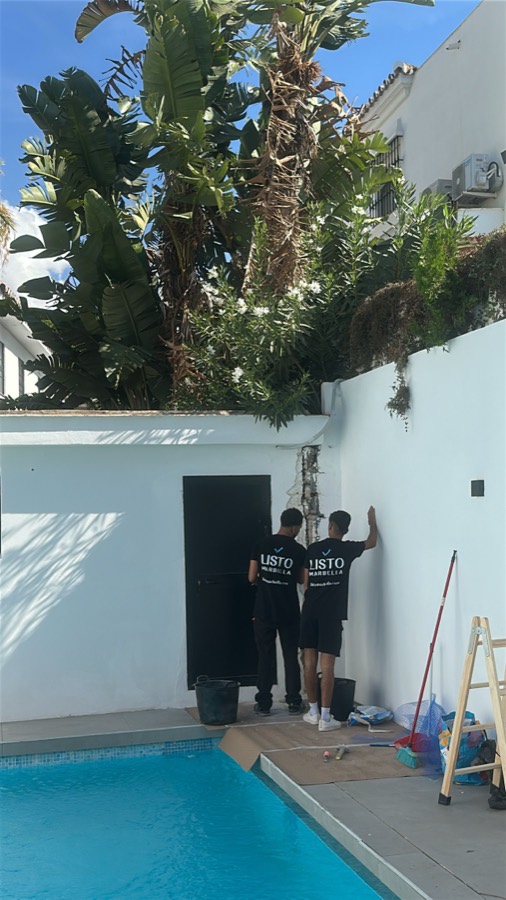 Dos profesionales de Listo trabajando junto a la piscina